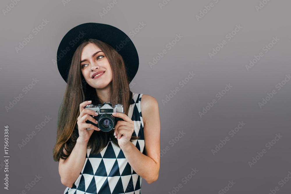 Stylish woman photographer with retro camera on the grey wall background. Image with copy space
Stylish woman photographer with retro camera on the grey wall background. Image with copy space