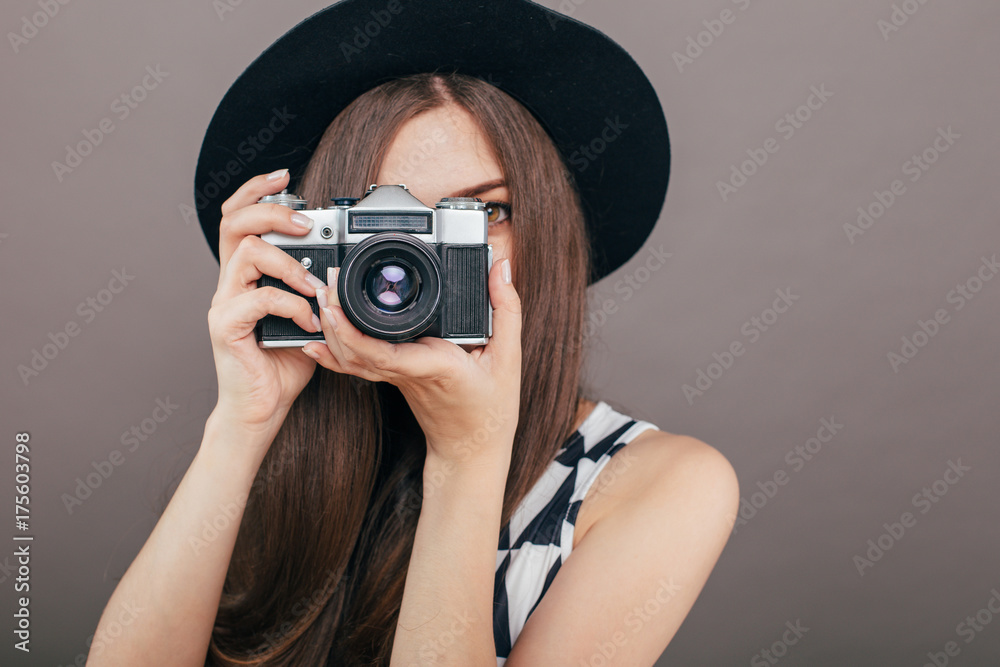 Stylish woman photographer with retro camera on the grey wall background. Image with copy space
Stylish woman photographer with retro camera on the grey wall background. Image with copy space