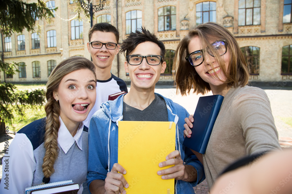 Cheerful selfie photo of a group of students on a university background. Four friends. Cheerful selfie photo of a group of students on a university background. Four friends.