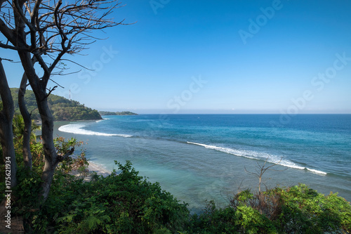 Beautiful landscape of blue beach with white sand and palm trees in Senggigi Beach at Lombok island, West Nusa Tenggara, Indonesia © sirintra