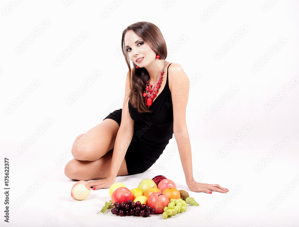 Portrait of slim fitness cheerful girl lying in studio with set of fruit and vegetables over white background. Portrait of slim fitness cheerful girl lying in studio with set of fruit and vegetables over white background.