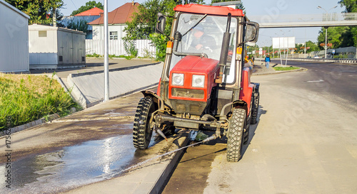 Tractor washes road in the city