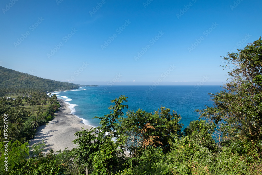 Beautiful landscape of blue beach with white sand and palm trees in Senggigi Beach at Lombok island, West Nusa Tenggara, Indonesia