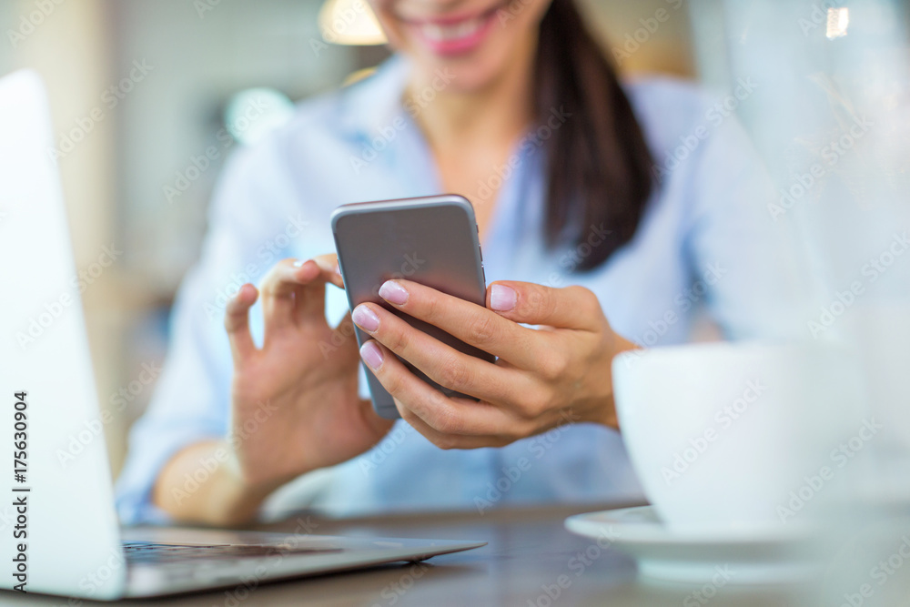 Woman using mobile phone at cafe
