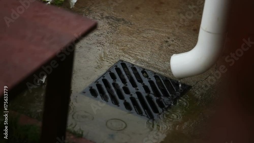 Rain pours out of a rain gutter and downspout, close up