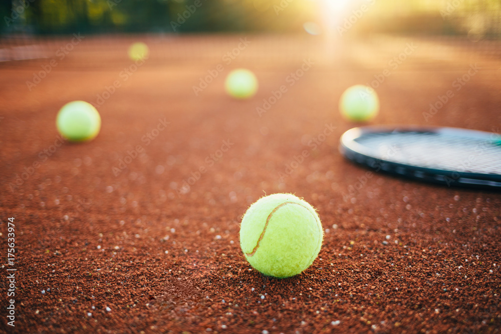Tennis balls and racket on tennis court