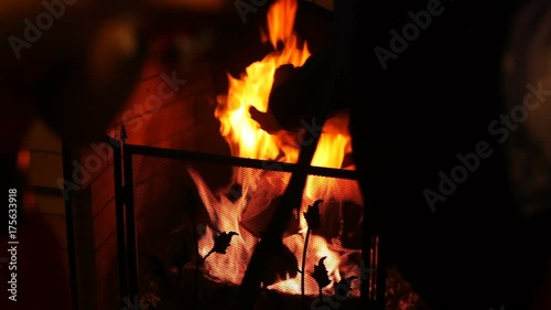 Fireplace with fire and firewood, orange, protected by a grid, in the house