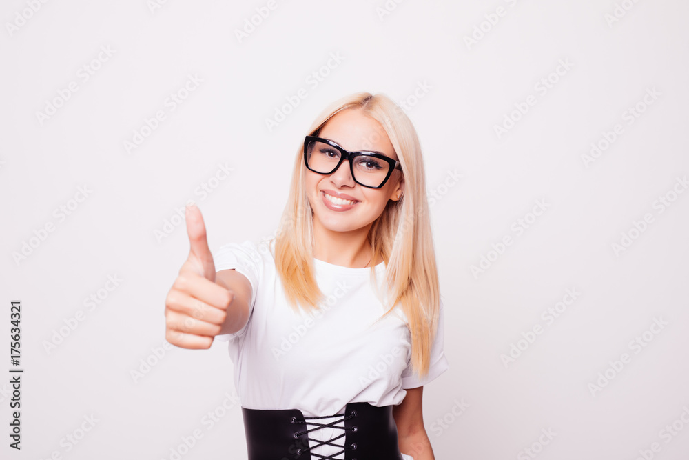 Smiling pretty young woman showing thumbs up isolated on the white background