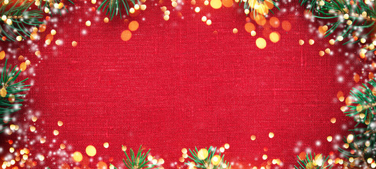 Christmas background with xmas tree, glitter bokeh lights, snow on red canvas background. Merry christmas greeting card, frame, banner. Winter holiday theme. Happy New Year. Space for text