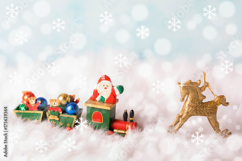 Santa Claus carries gifts on a wooden train.