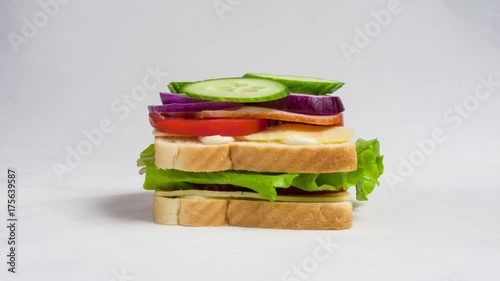 Time lapse of making a big sandwich with tomato, ham, cheese and salad. Stop motion of preparing snacks