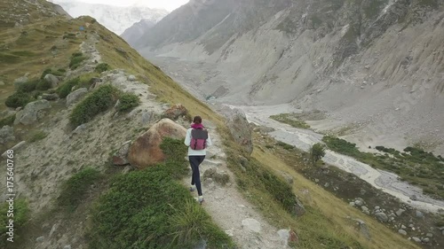Girl walking along narrow summit ridge crest in the evening