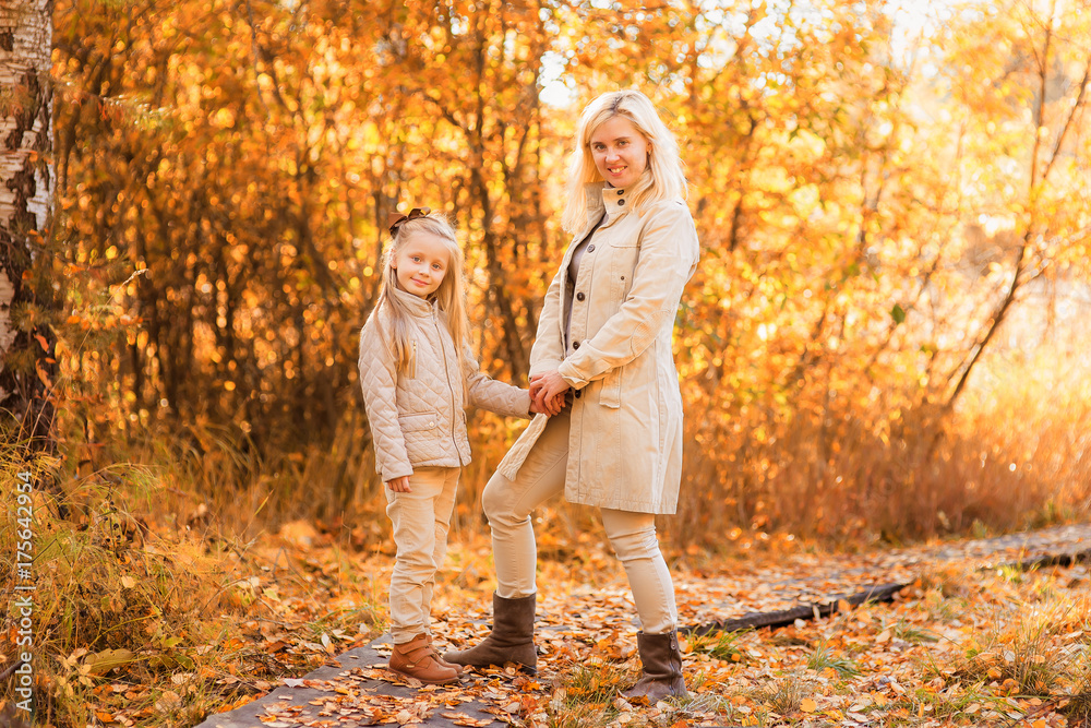 Mom and daughter walk in autumn park Mom and daughter walk in autumn park