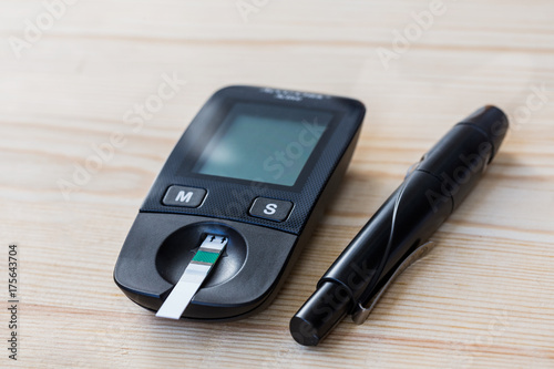 Set glucometer and syringe with Diabetes Indicator Strips For Blood Glucose Testing wood on white background photo