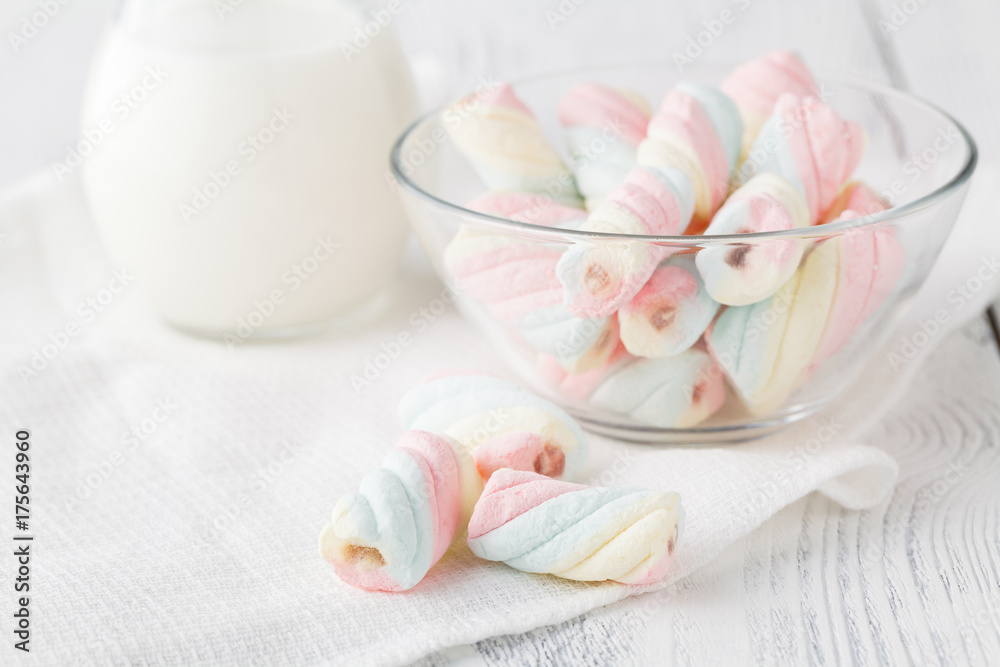 Pile of american twisted marshmallow on table with glass of milk