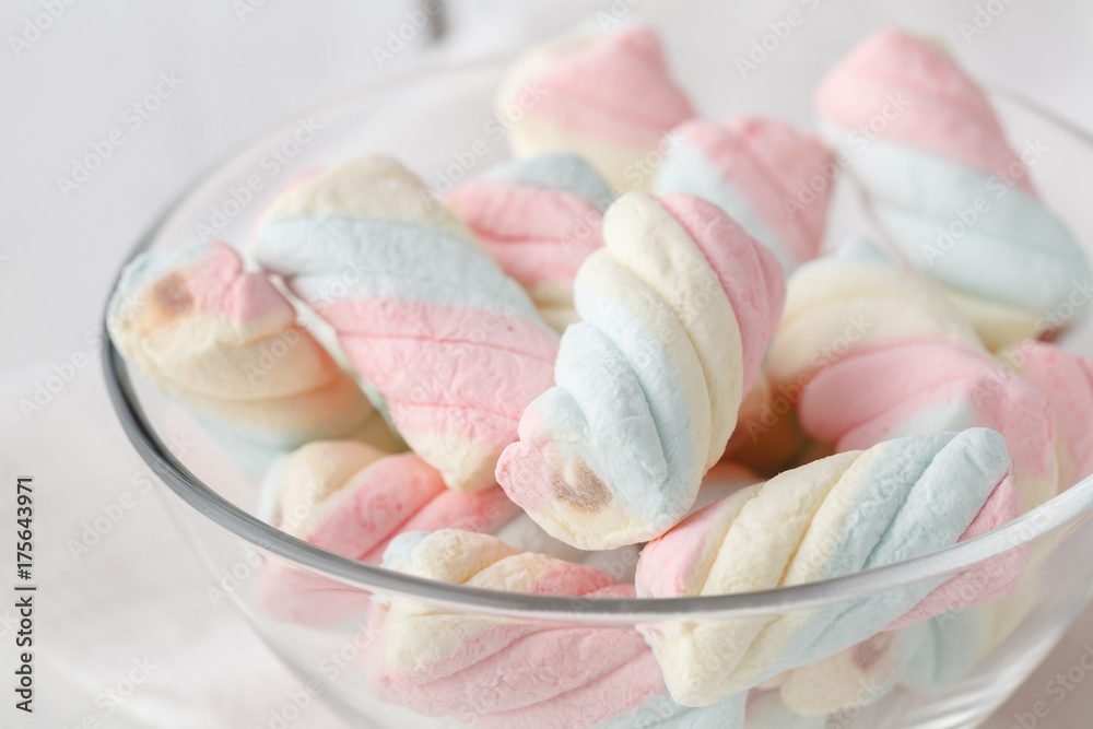 Pile of american twisted marshmallow on table with glass of milk Pile of american twisted marshmallow on table with glass of milk