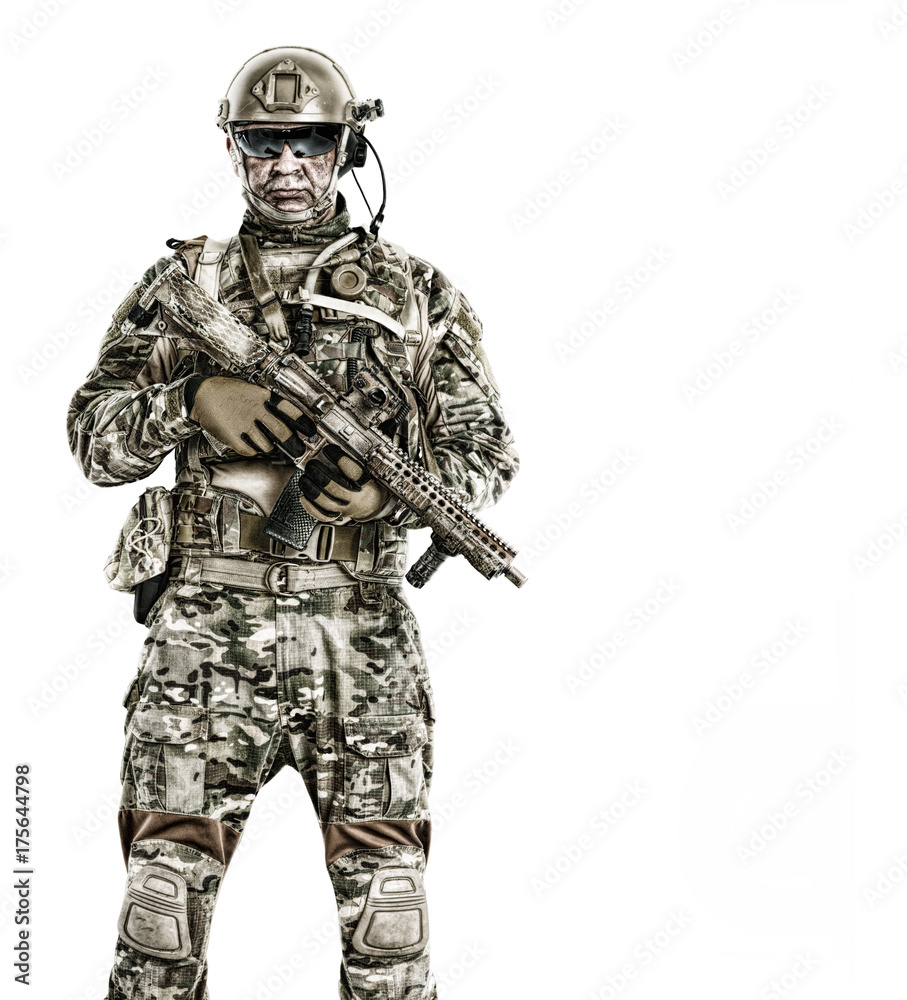 Half length low angle studio shot of special forces soldier in field uniforms with weapons, portrait isolated on white background, front view. Protective goggles glasses are on Half length low angle studio shot of special forces soldier in field uniforms with weapons, portrait isolated on white background, front view. Protective goggles glasses are on