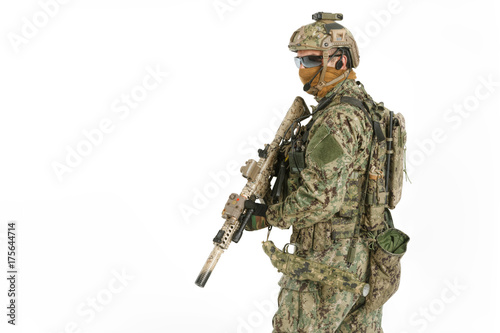 Half length low angle studio shot of special forces soldier in field uniforms with weapons, portrait isolated on white background. Protective goggles glasses are on