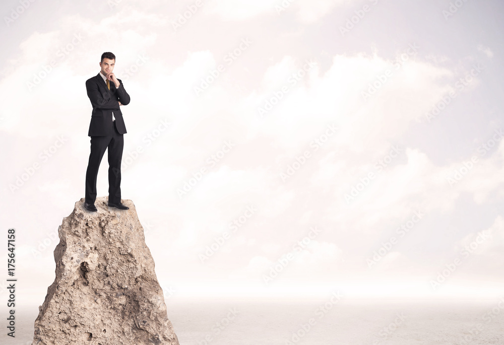 Happy businessman standing on cliff Happy businessman standing on cliff