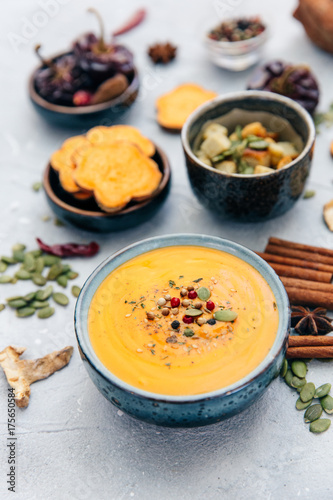 Bowl with fresh homemade carrot pumpkin soup and spices.