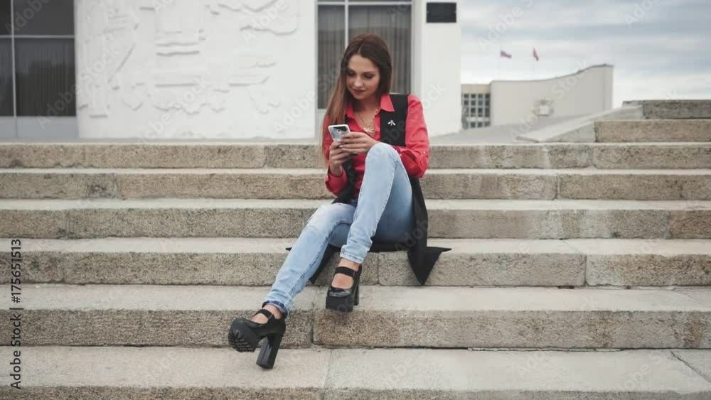 Young woman with smartphone sitting on stairs in the city Young woman with smartphone sitting on stairs in the city