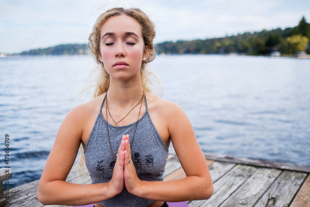 Beautiful young woman practicing yoga near a lake Beautiful young woman practicing yoga near a lake