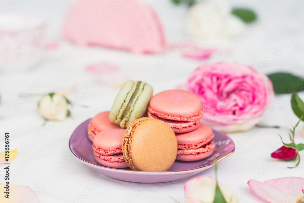 macarons and roses on an embroidered cloth macarons and roses on an embroidered cloth