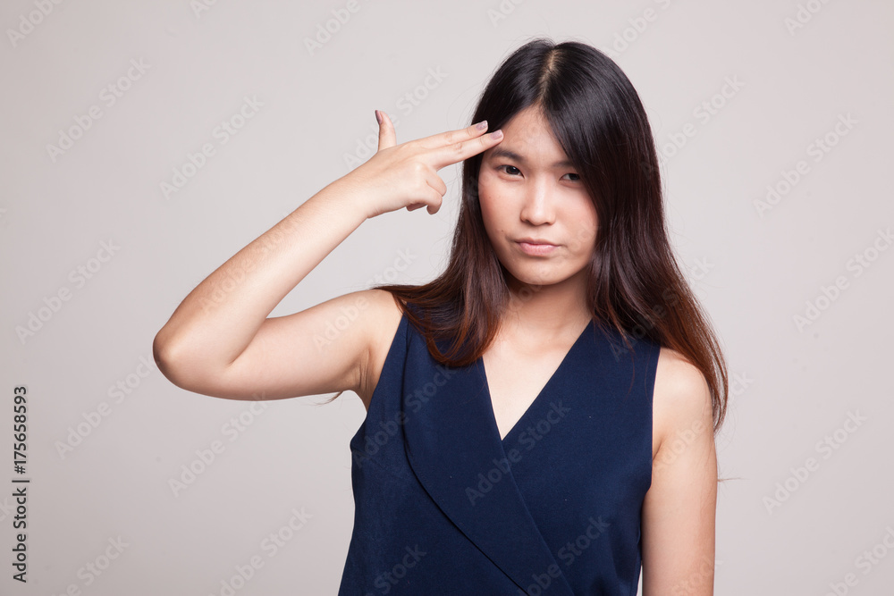 Beautiful young Asian woman holding fingers in gun gesture. Beautiful young Asian woman holding fingers in gun gesture.