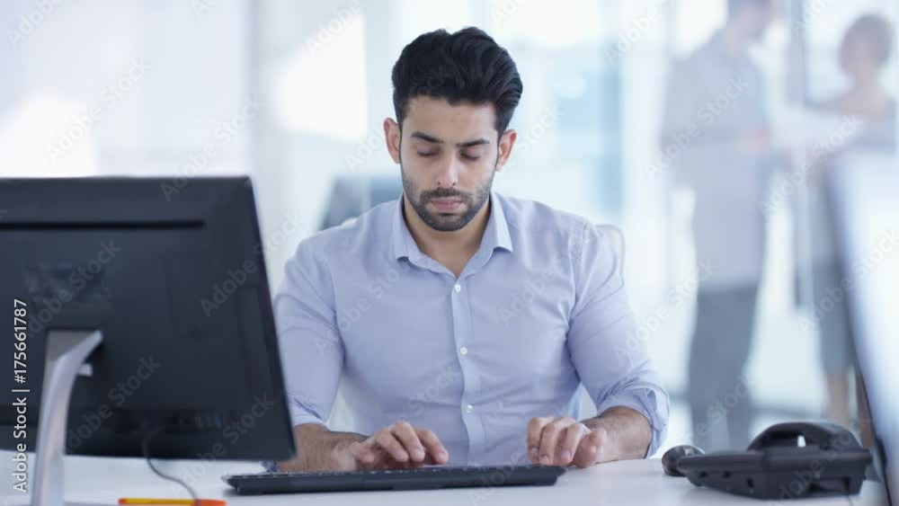  Businessman working on computer at his desk in modern office