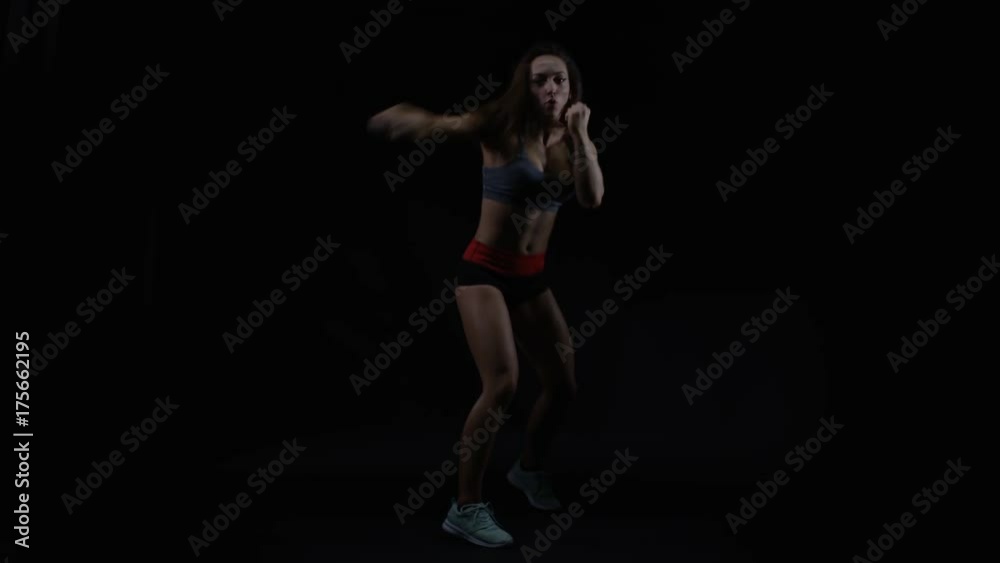 Female boxer training, throwing punches towards camera with bare fists Female boxer training, throwing punches towards camera with bare fists