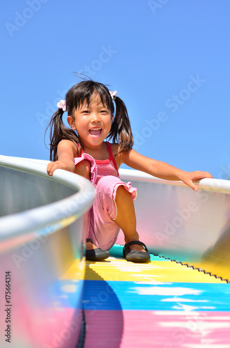 公園の滑り台で遊ぶ女の子