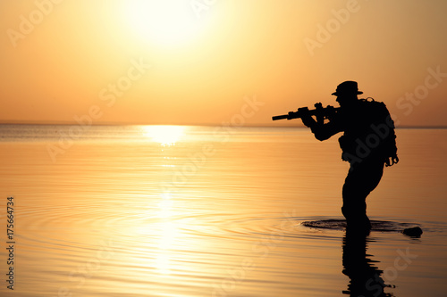 Army soldier with rifle orange sunset silhouette