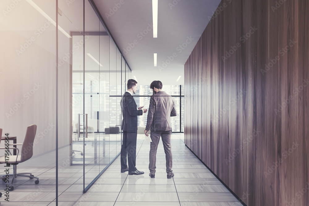 People in a glass and wooden office corridor
