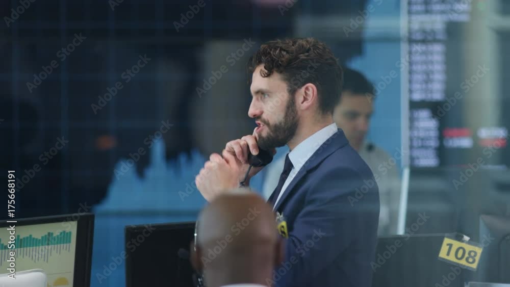Financial trader in busy stock exchange celebrates making a successful deal Financial trader in busy stock exchange celebrates making a successful deal