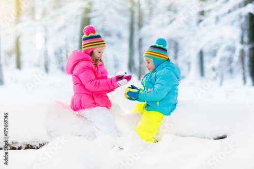 Kids playing in snow. Children play outdoors in winter snowfall.