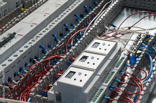 A series of modular magnetic contactors and a range of power circuit breakers. Between the rows of contactors and switches and devices, perforated cable channels. They laid the electrical wire.