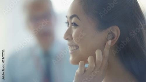  Close up woman with deafness very happy after putting in hearing aid