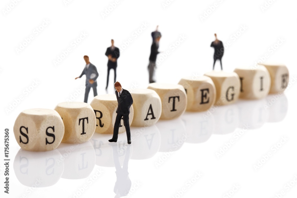 Strategie, German for strategy, written with wooden letters and miniature manager figures Strategie, German for strategy, written with wooden letters and miniature manager figures