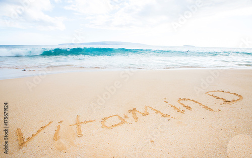 Vitamin D written in the sand at a tropical beach