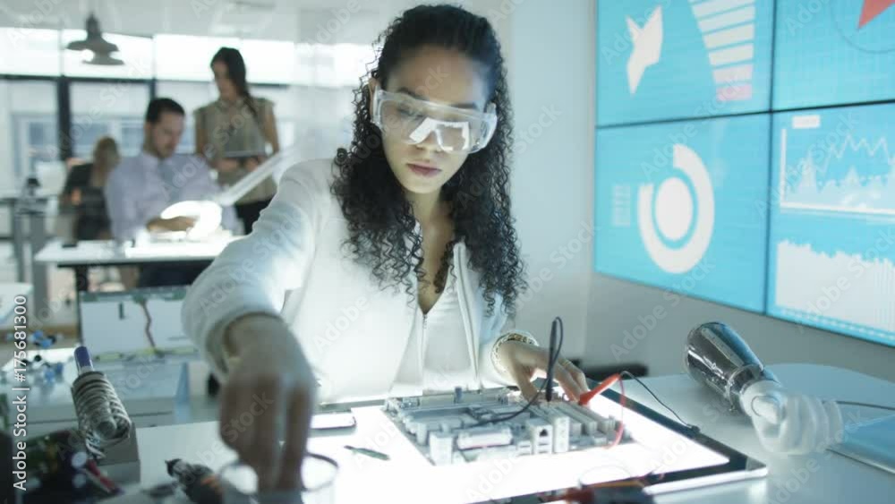  Electronics engineers working in lab with woman building circuit board