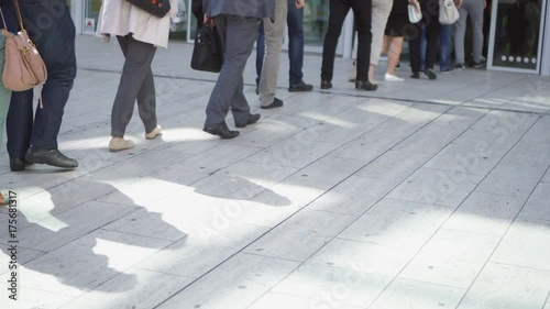 Legs of people walking and standing in line outside. Business people in queue in Paris business district La Defense