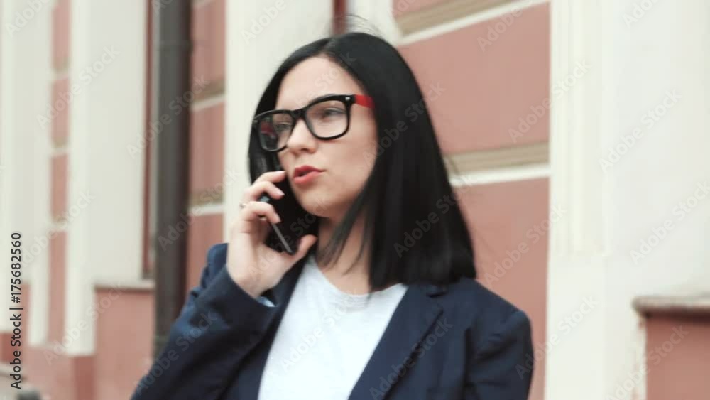 Businesswoman with smartphone close up. Girl speaks on cell phone. Beautiful woman in glasses talks on the mobile device, Female with white smartphone. Businesswoman with smartphone close up. Girl speaks on cell phone. Beautiful woman in glasses talks on the mobile device, Female with white smartphone.