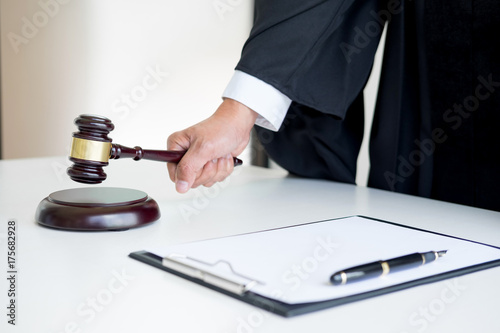 Male Judge lawyer In A Courtroom Striking The Gavel on sounding block