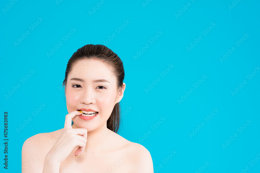 Young Asian woman biting finger nail isolated on blue background. Young Asian woman biting finger nail isolated on blue background.