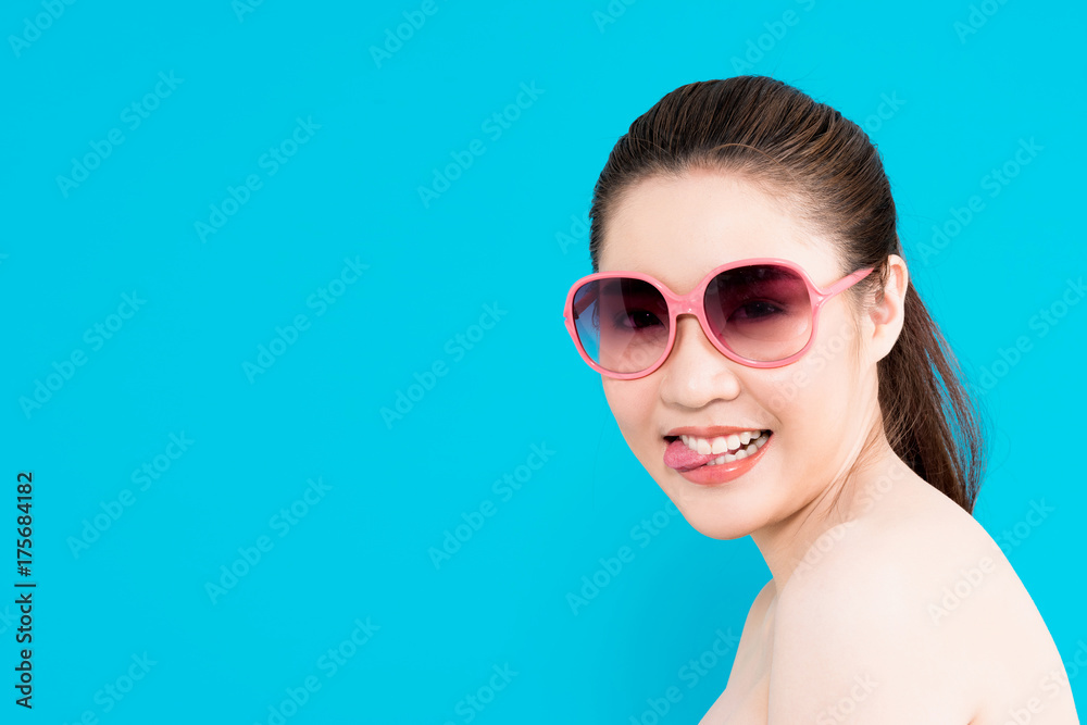 Young Asian woman biting finger nail isolated on blue background.