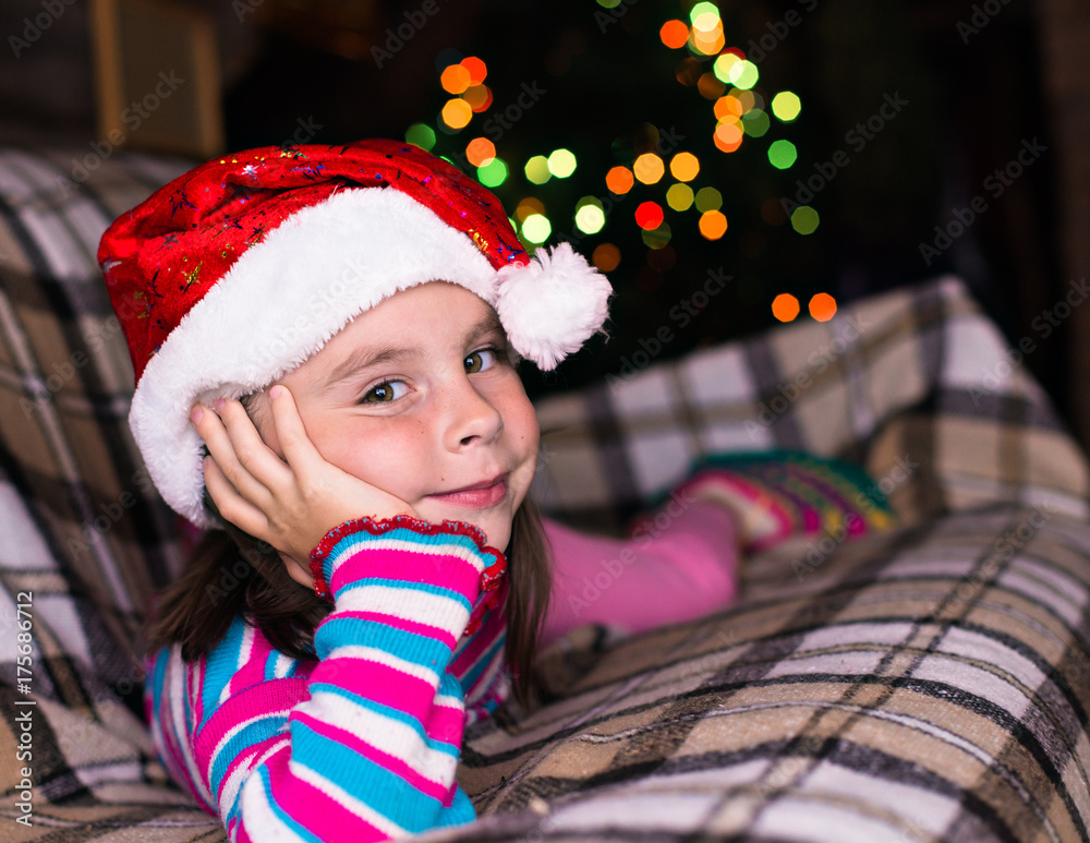 Happy child girl in a Christmas hat waiting for a miracle. Happy child girl in a Christmas hat waiting for a miracle.