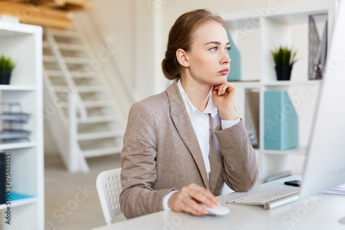 Fotografi Pensive analyst sitting in front of computer monitor and networking