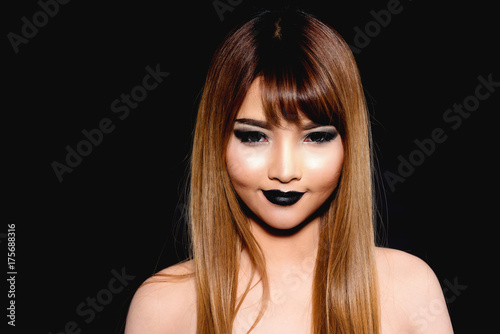 Gothic Young Asian woman isolated on black background.
