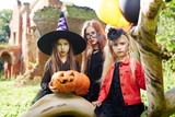 Group of sulky girls with carved halloween pumpkin celebrating holiday