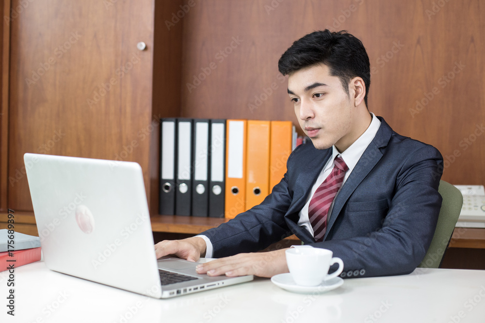 Asian Young Businessman working at office, Businessman using Laptop for work, People working concept. Asian Young Businessman working at office, Businessman using Laptop for work, People working concept.